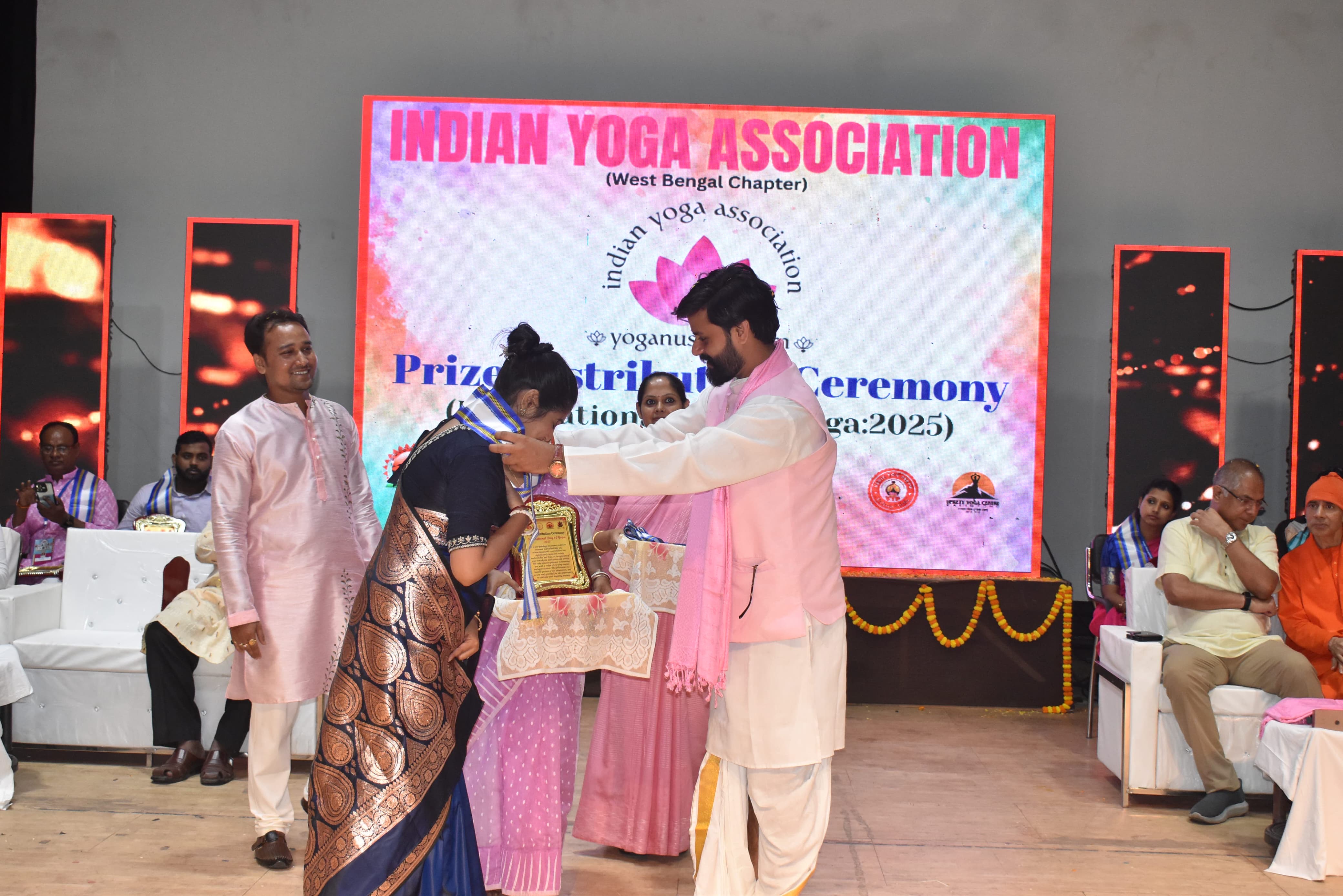Dr. Shivam Mishra lighting ceremonial lamp at Indian Yoga Association event